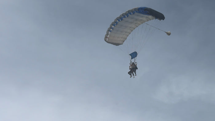 Person paragliding against a cloudy sky