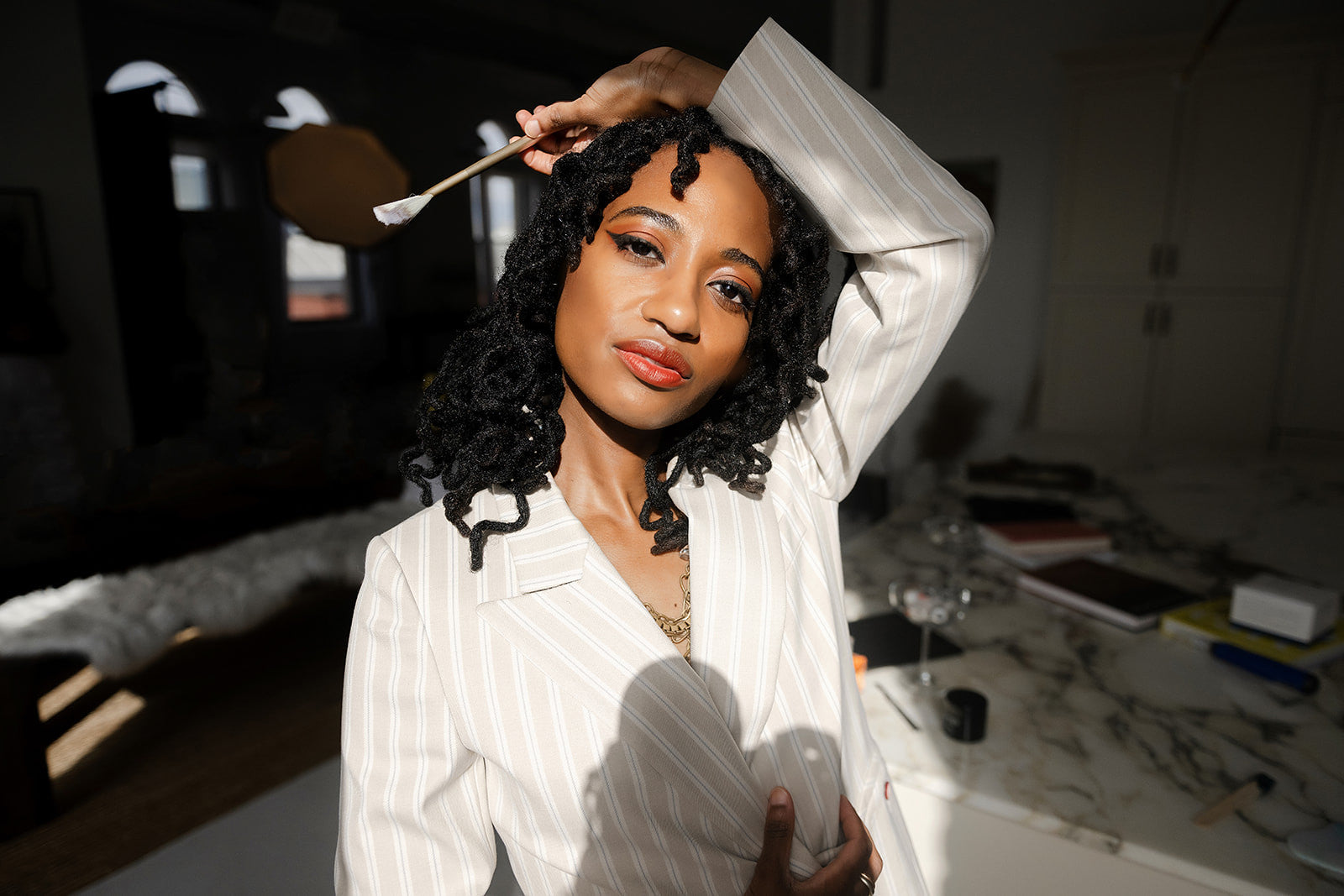 Woman styling her hair with a brush in a room setting