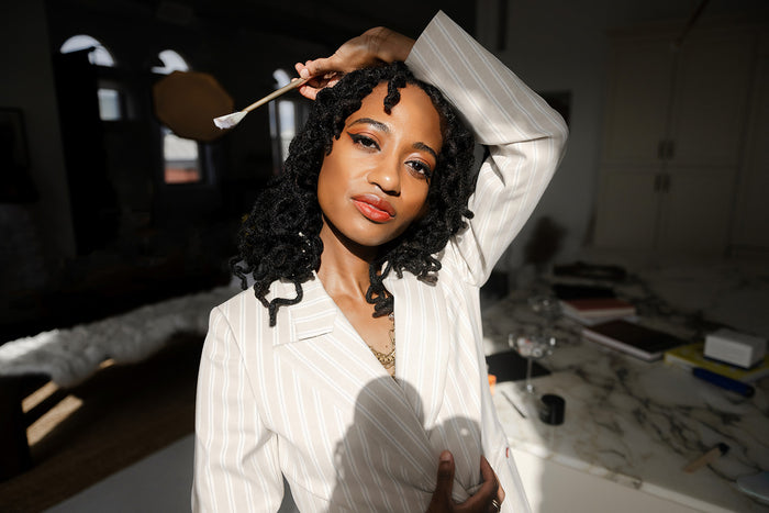 Woman styling her hair with a brush in a room setting